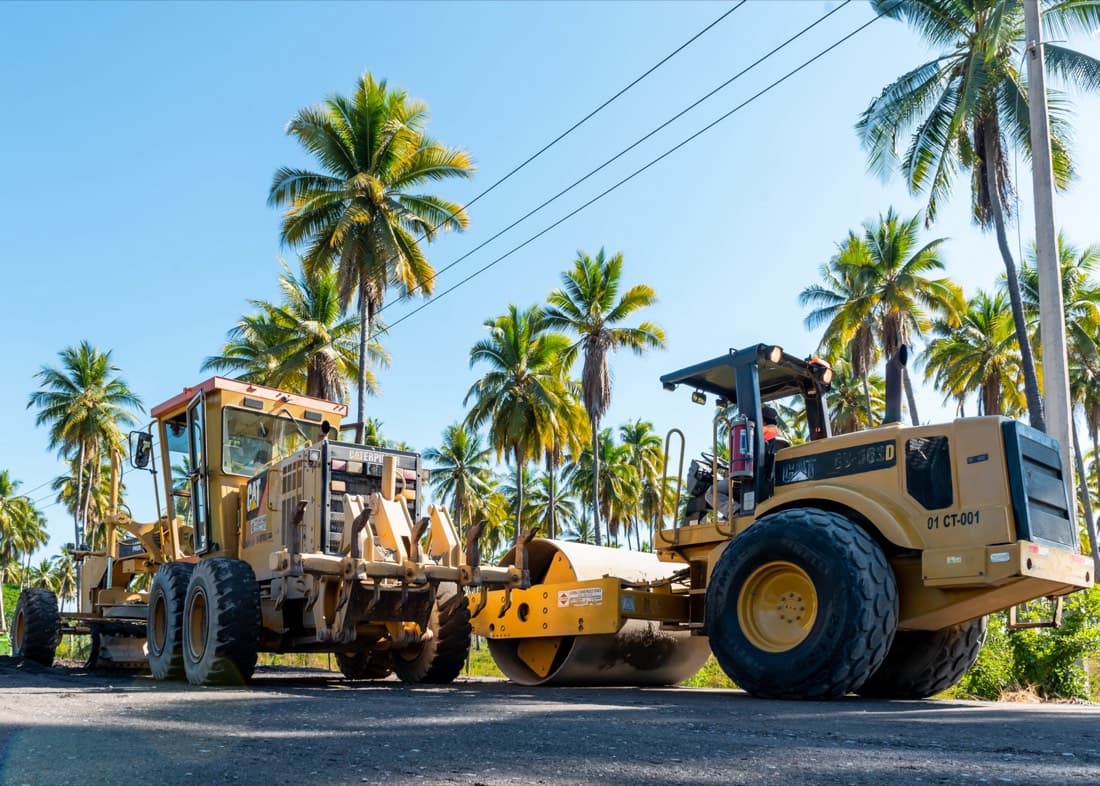 Motoconformadora y rodillo compactador trabajando un tramo de terracería